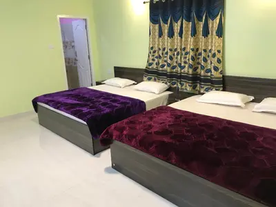 two beds in a room with purple sheets at HAPPYSTAY rooms and cottages in Ooty