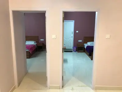 a room with two beds and a hallway with two beds at HAPPYSTAY rooms and cottages in Ooty