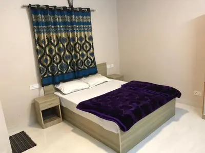 a bedroom with a bed with a blue curtain at HAPPYSTAY rooms and cottages in Ooty