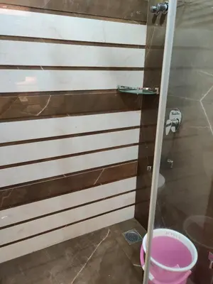 a bathroom with brown and white stripes on the wall at Neermala Residency in Coimbatore