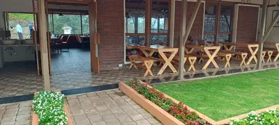 a restaurant with tables and chairs in a building at Yantra Resort, Ooty in Ooty