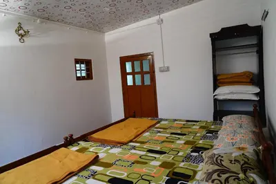 a bedroom with a bed with a colorful quilt at Bison Valley Estate in Vālpārai