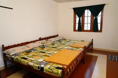 a bed in a room with two tables in it at Bison Valley Estate in Vālpārai