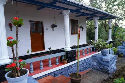 a house with potted plants in front of it at Bison Valley Estate in Vālpārai
