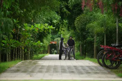 a man and a woman standing next to a bike at Coffee Greens Resort in Wayanad