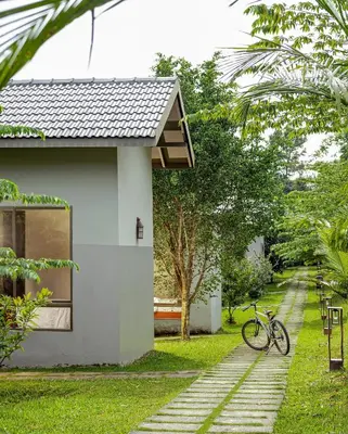 a bike parked next to a white house at Coffee Greens Resort in Wayanad