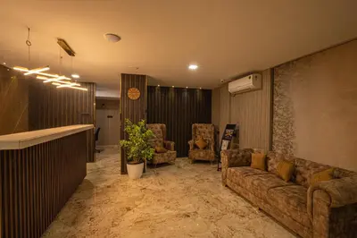 a living room with a couch and two chairs at Windstone Residency in Coimbatore