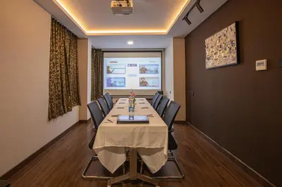 a conference room with a long table and chairs at Windstone Residency in Coimbatore