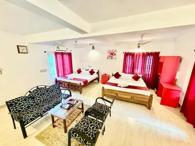 a living room with two beds and a couch at Coorg Nest Cottages By Dreamy Vacations in Kushālnagar