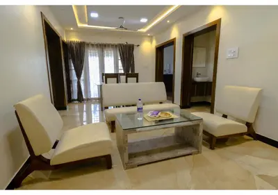 a living room with a couch and a table and chairs at SR BOUTIQUEE STAY in Coimbatore
