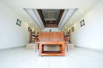 a wooden bench in the middle of a room at Velan Temple View in Palani