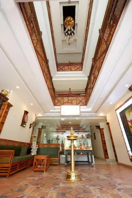 a lobby of a building with a ceiling at Velan Temple View in Palani