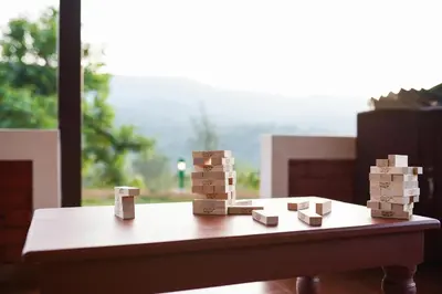 a pile of wooden blocks on a table with a window at Zostel Homes Wayanad, Thirunelly in Wayanad