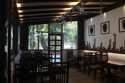 a dining room with chairs and tables and windows at VANYA by Citrine in Nelliyampathy