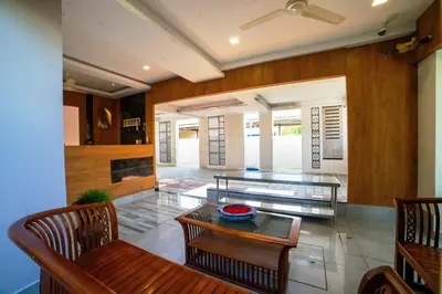 a living room with a glass table and chairs at Sarvam Serviced Apartment in Coimbatore