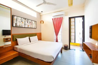 a bedroom with a bed and a flat screen tv at Sarvam Serviced Apartment in Coimbatore