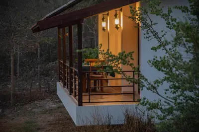 a screened in porch of a house with a table at Dhole's Den Bandipur in Bandipūr