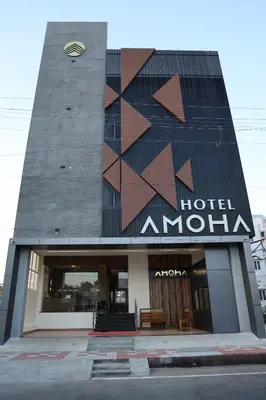 a hotel with a building with a sign on it at Hotel Amoha in Palani