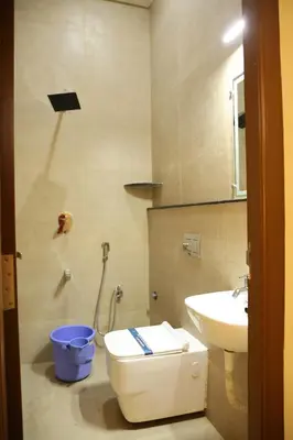 a bathroom with a toilet and a sink at Hotel Amoha in Palani
