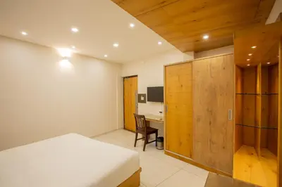 a bedroom with a bed and a desk with a chair at Hasco Tower in Palakkad