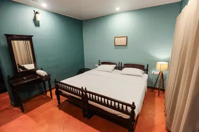 a bedroom with a bed and a table and a mirror at Hill Rows Plantation and Forest Experience By GreenEscapes in Vythiri