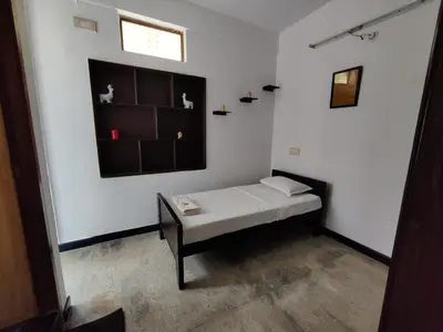 a small room with a bed and a table at Yoga House in Vānivilāsa Puram