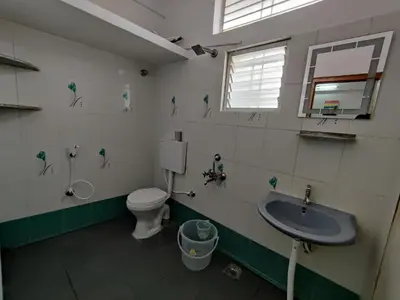 a bathroom with a toilet and a sink at Yoga House in Vānivilāsa Puram