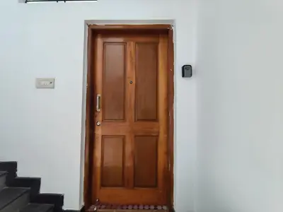 a wooden door on the side of a building at Yoga House in Vānivilāsa Puram