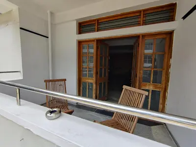 a balcony with two chairs and a door at Yoga House in Vānivilāsa Puram