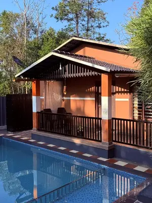a villa with a pool and a house at Wayanad Cocos Villa in Tariyod