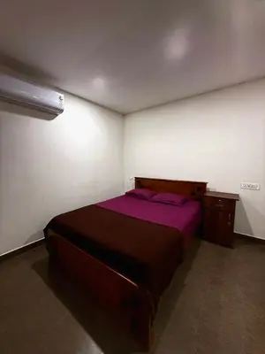 a bedroom with a bed with purple sheets and a desk at Wayanad Cocos Villa in Tariyod