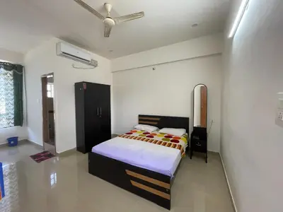 a bedroom with a bed and a ceiling fan at Green Valley Residency in Gundlupet