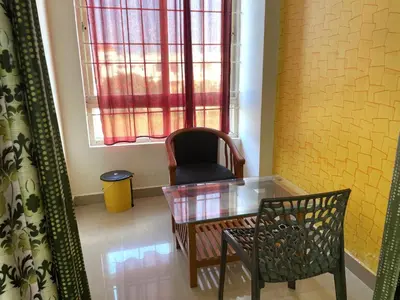 a dining room with a glass table and a chair at Green Valley Residency in Gundlupet