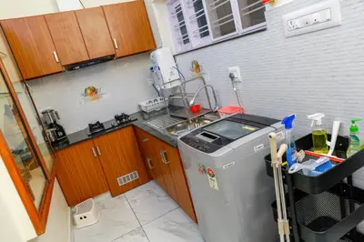a kitchen with a sink and a washing machine at Belljem Homes -your own private resort -3 BHK FF in Trichūr