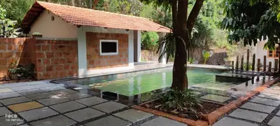 a swimming pool with a tree in front of a house at the motville - Serene Family Retreat & Private Pool in Pulpally