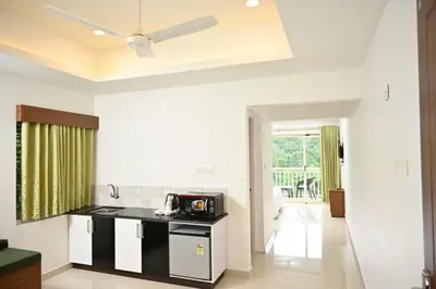 a kitchen with a black counter and a microwave at Riviera inn resort in Chillithodu