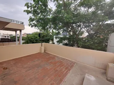 a balcony of a house with a fence and a tree at Kavitha House Homestay in Mysore