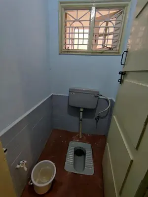 a small bathroom with a toilet with a window at Kavitha House Homestay in Mysore