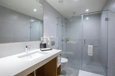 a bathroom with a shower and a sink and a toilet at IKON By Annapoorna in Coimbatore