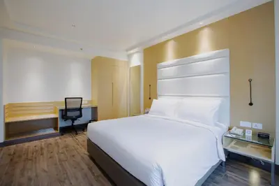 a bedroom with a large white bed and a desk at IKON By Annapoorna in Coimbatore