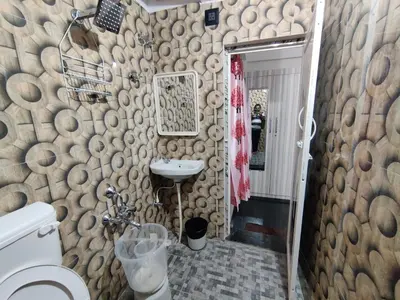 a bathroom with wooden logs on the wall at Royal Wings Apartments in Mysore