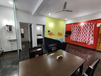 a living room with a table and a couch at Royal Wings Apartments in Mysore