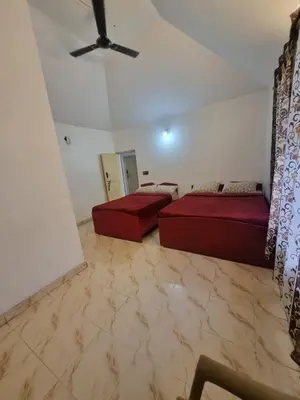 a bedroom with two beds and a ceiling fan at Royal Mist in Ooty