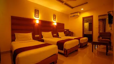 a hotel room with two beds and a chair at National Residency in Mysore