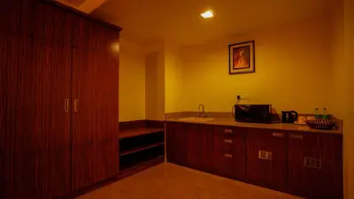 a room with a kitchen with a sink and a cabinet at National Residency in Mysore