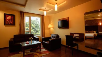 a living room with a couch chair and a television at National Residency in Mysore