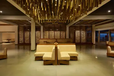 a lobby with chairs and a table and chandelier at MOUNTAIN SHADOWS RESORT Wayanad in Wayanad