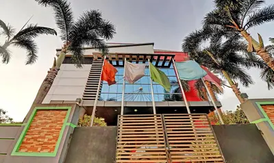 a building with palm trees in front of it at Treebo Symphony Hotels And Resorts Angamally in Kizhake Chālakudi