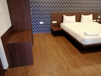 a bedroom with a bed and a wooden floor at HOTEL VINTAGE CASTLE in Coimbatore