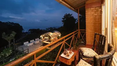 a balcony with a table and chairs on a house at De Rock Jungle Living Resort in Coonoor